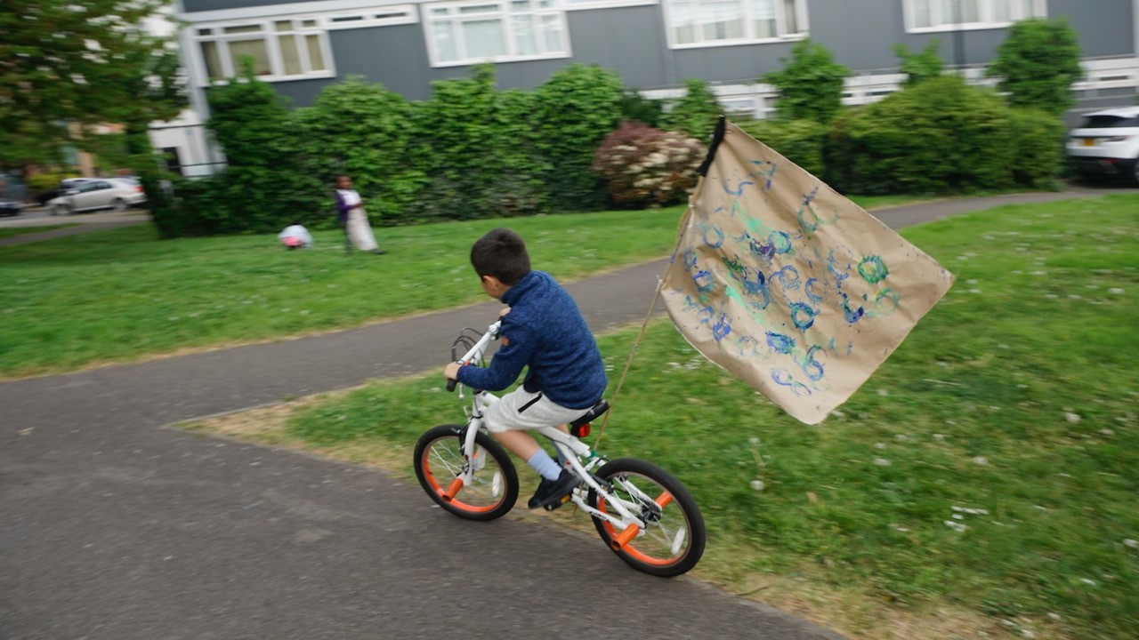 Child riding bike with flag attached to the back