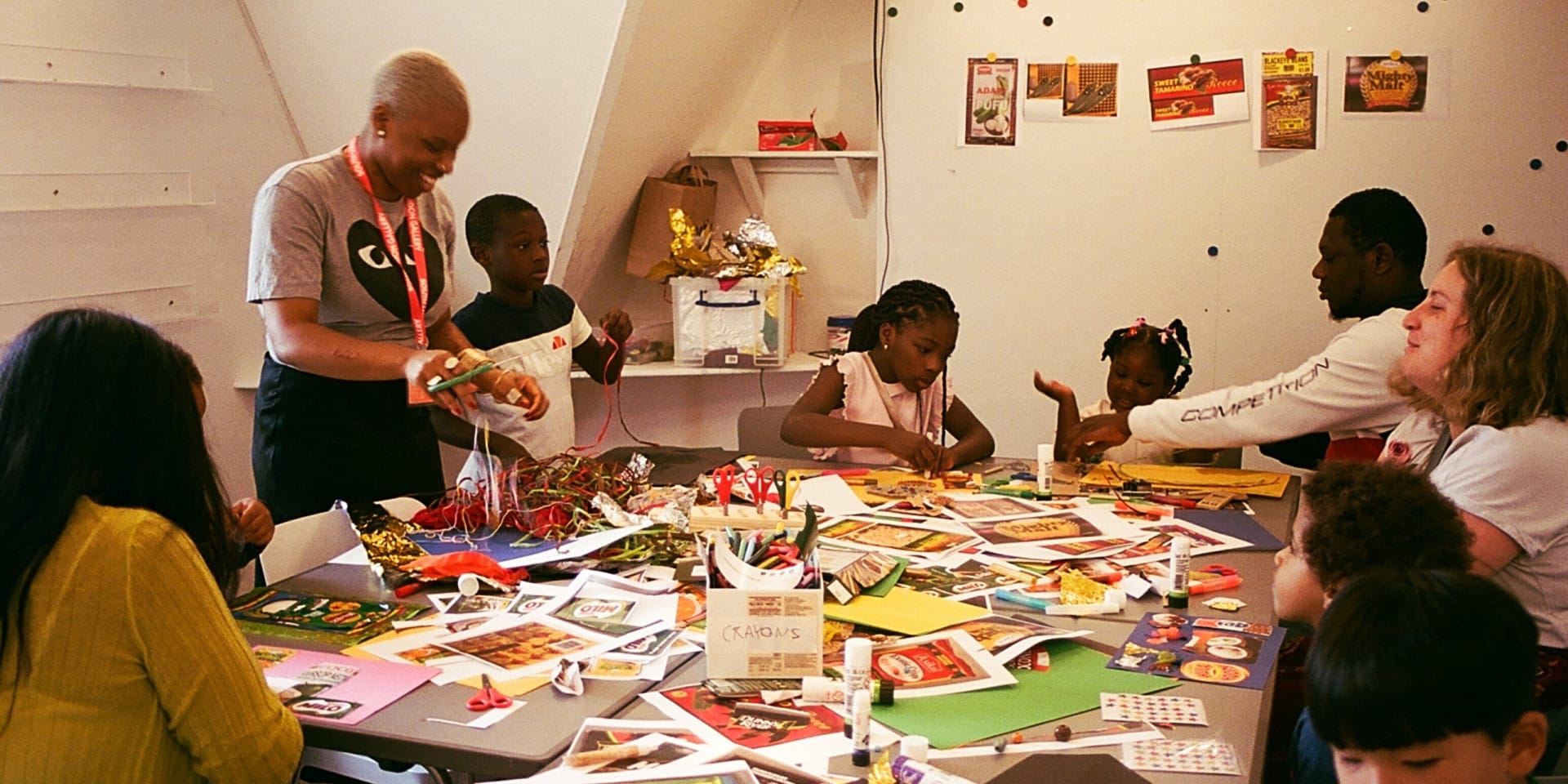 Children and adults in an art room collaging
